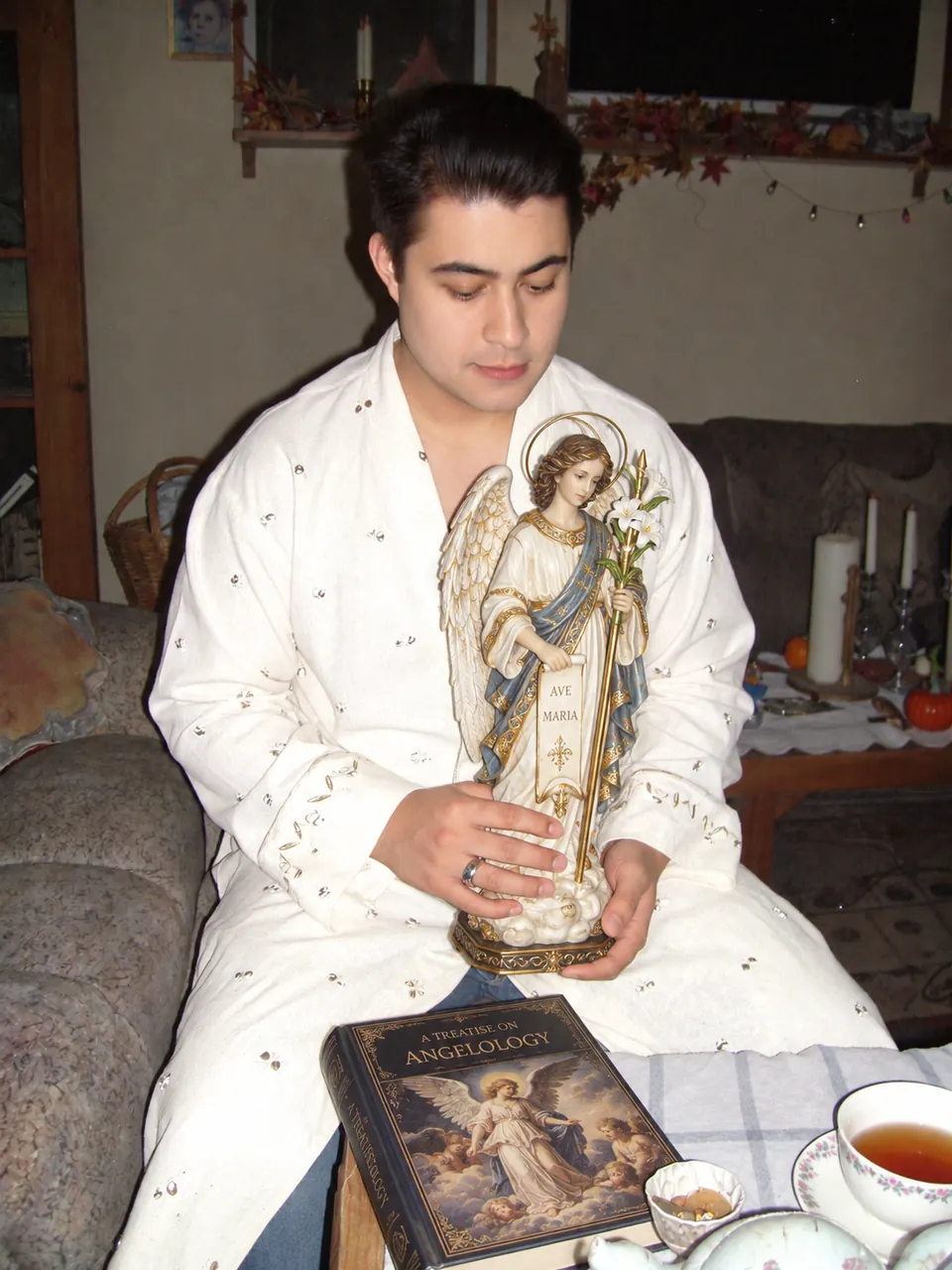 Igor Davis holding a guardian angel statue beside a treatise on angelology