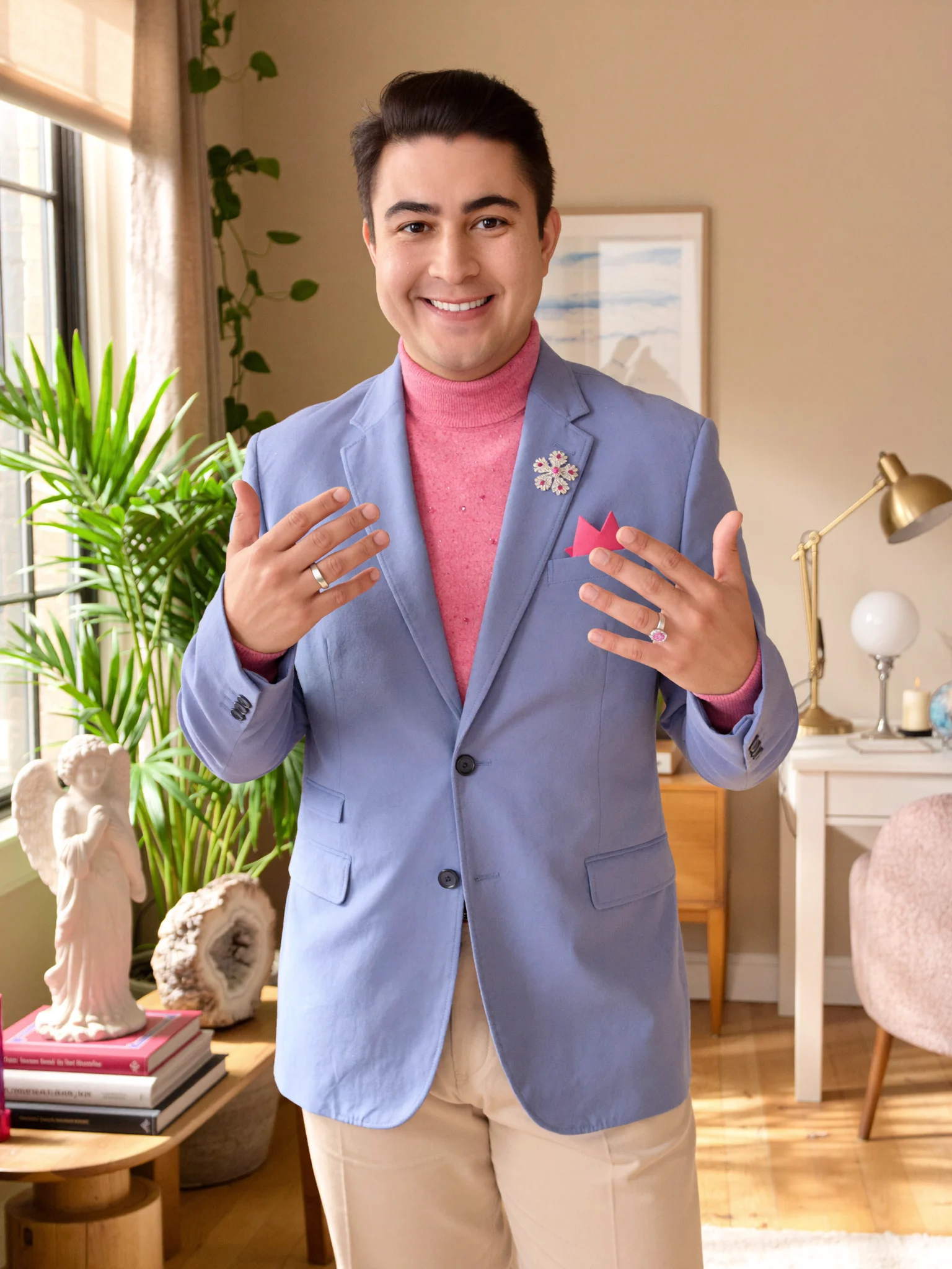Igor Davis, oracle and tarot reader in St. Augustine and Ponte Vedra, Florida, smiling in a bright room with an angel statue and crystals